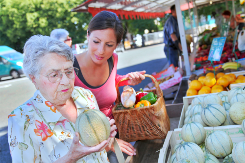elderly and woman buing fruits